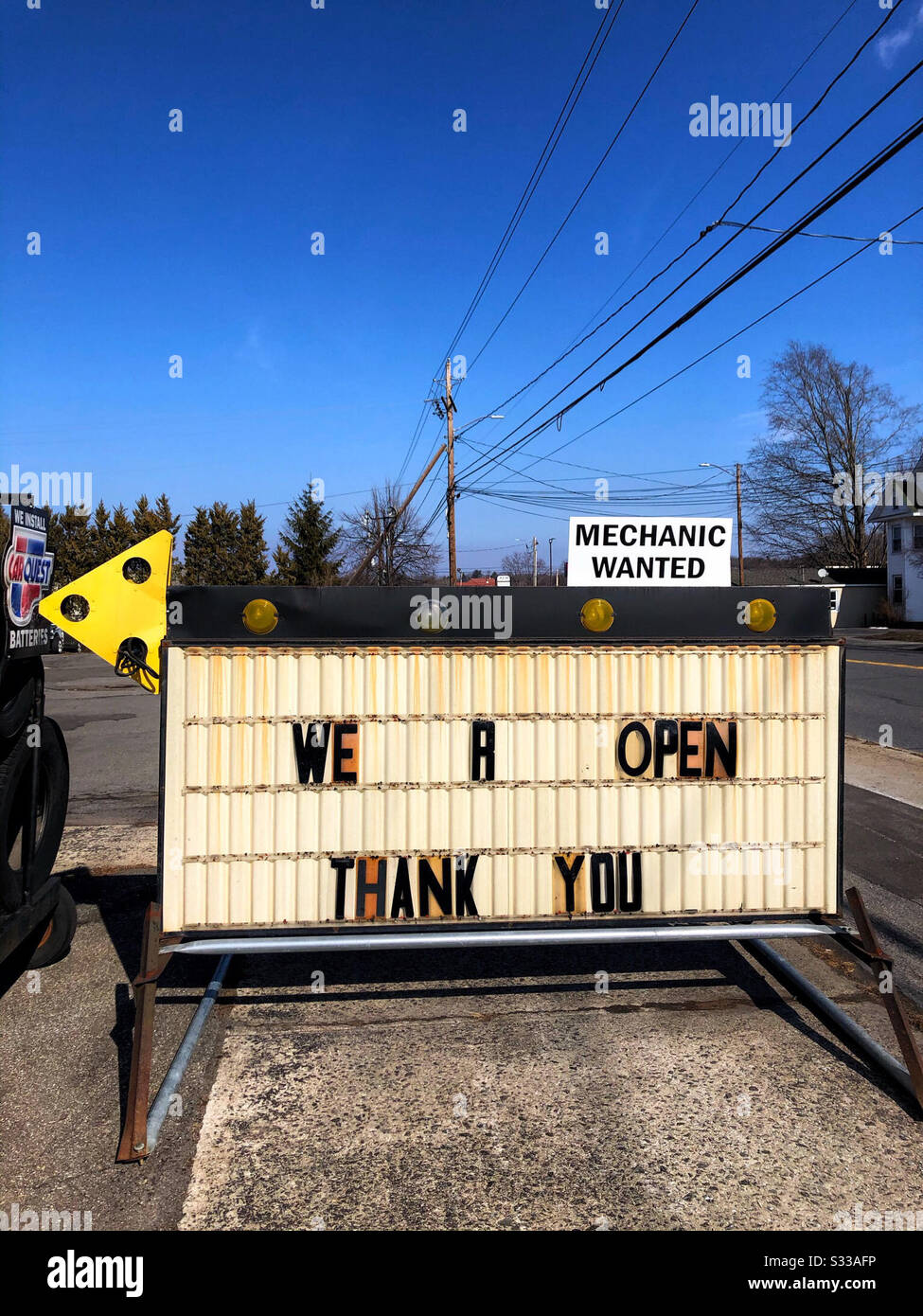Mechanic Wanted sign at car repair shop on the road - Smartphone Captured Stock Image