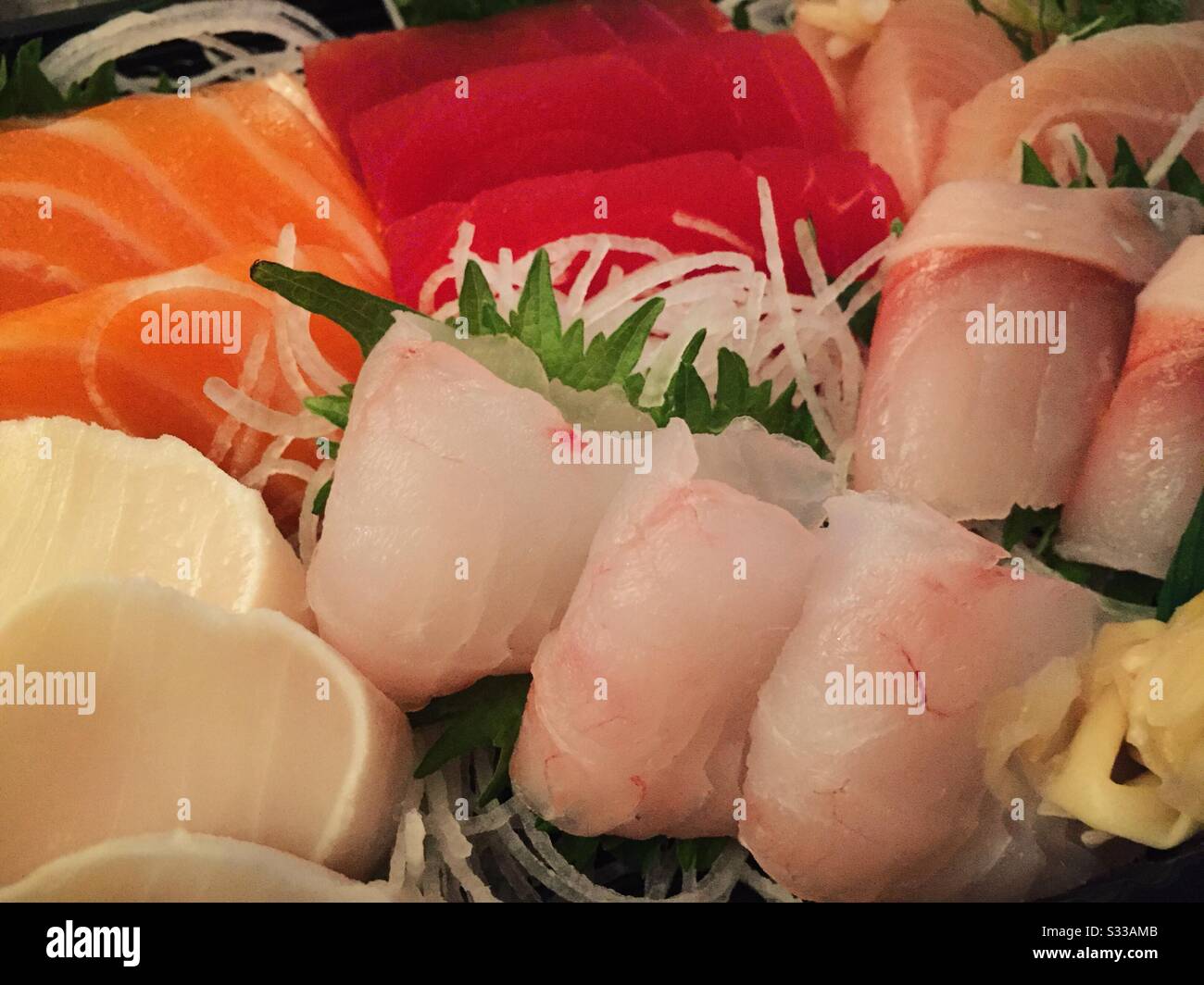 Sashimi dinner entrée features fresh pieces of manguro tuna and salmon among other fresh raw pieces of fish - Smartphone Captured Stock Image