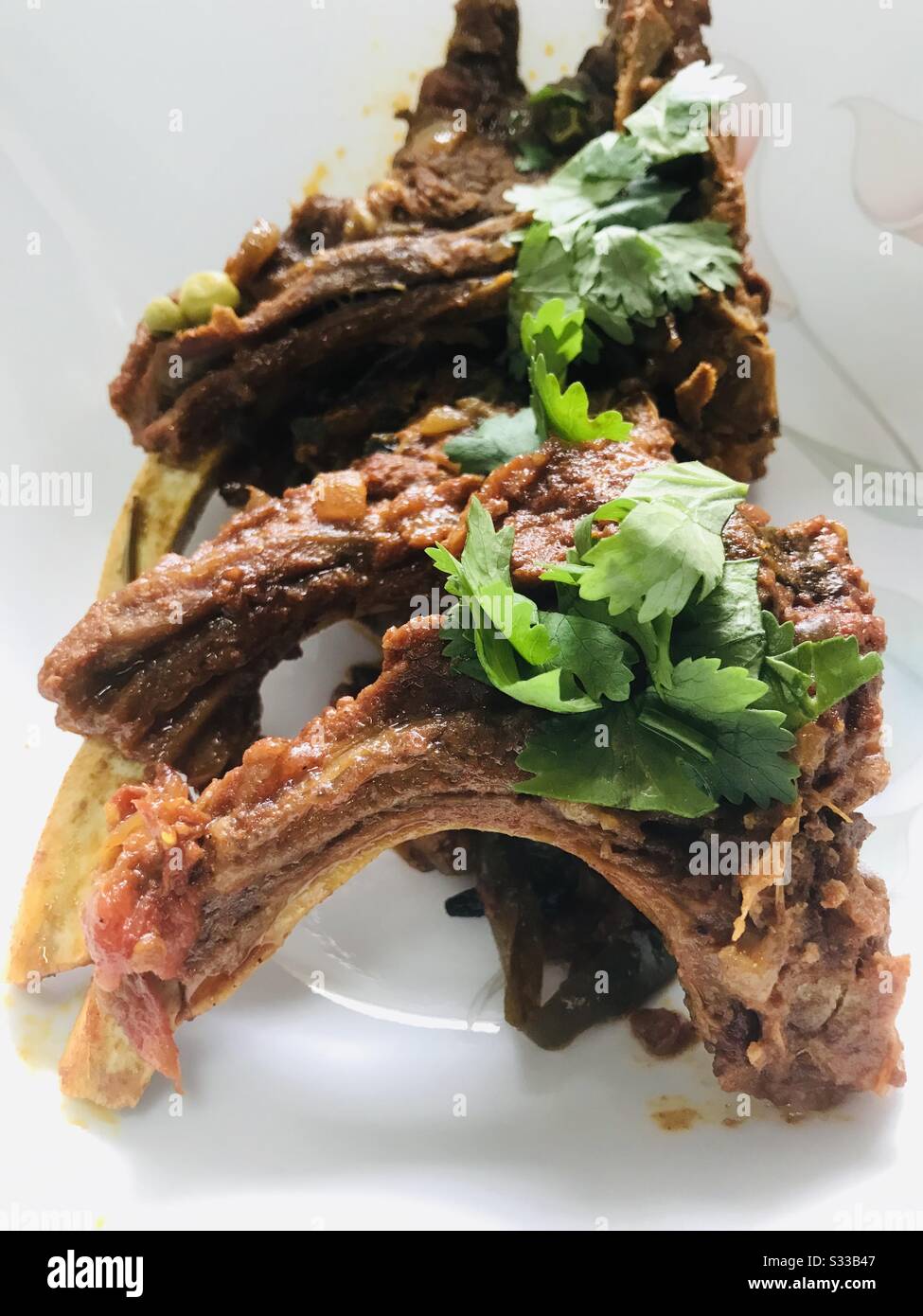 Home cooked Dhaba style mutton ribs dish on a white background , indian, Punjabi dish, steak