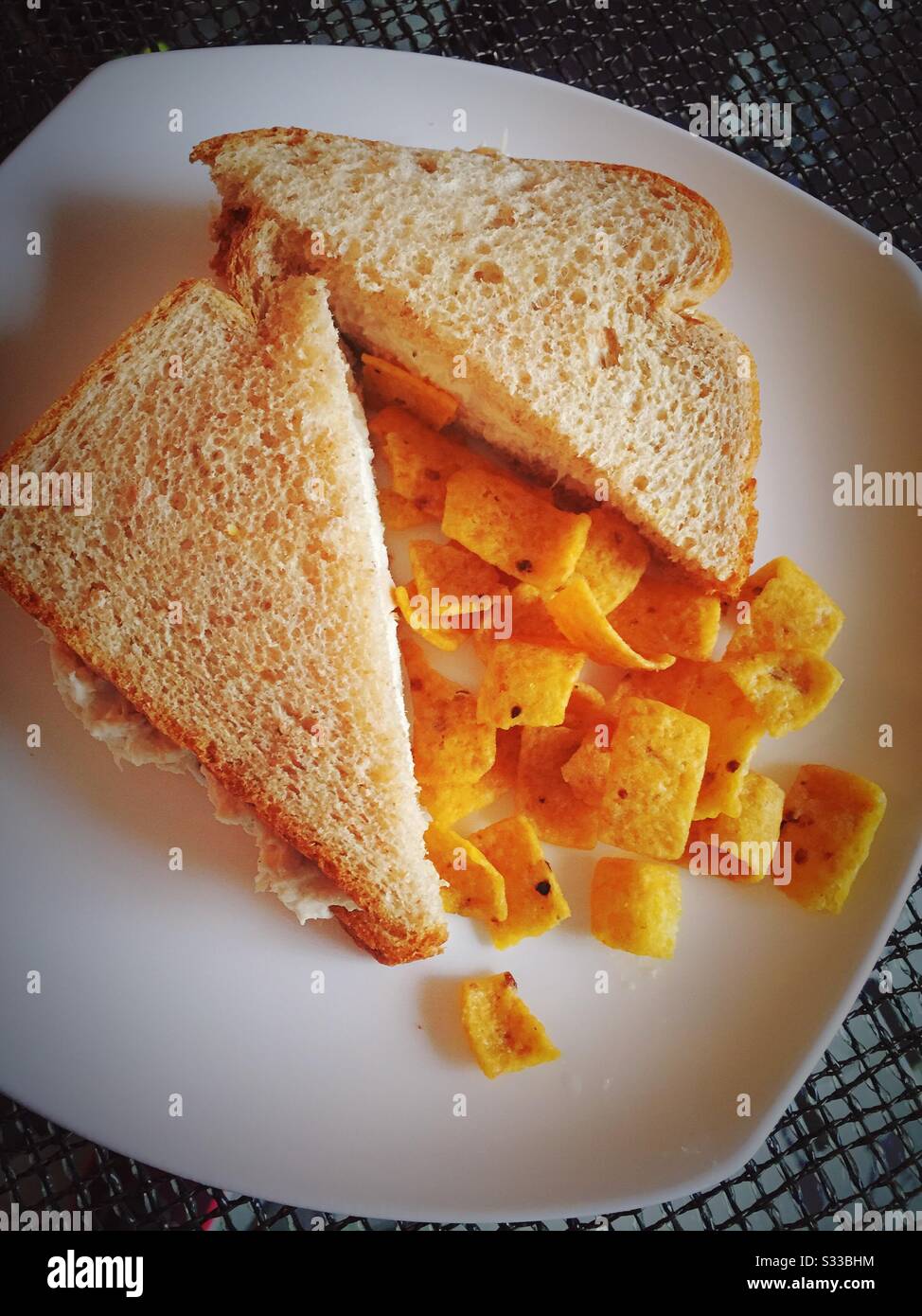 A tasty lunchtime meal of tuna sandwich on whole wheat bread with corn chips Stock Photo Alamy