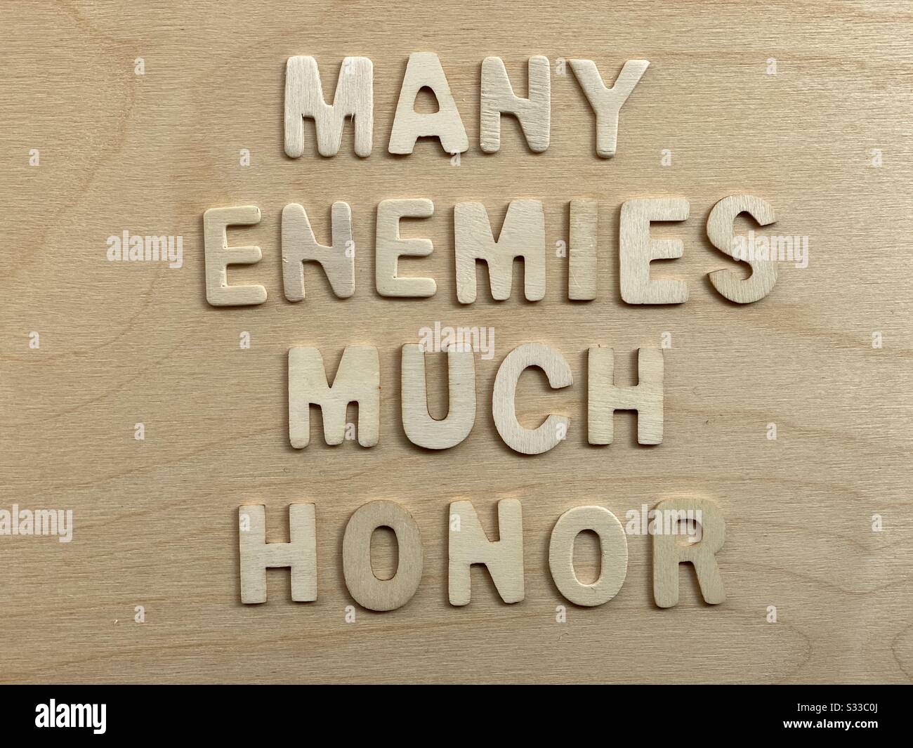 Many enemies, much honor, motivational quote composed with wooden letters - Smartphone Captured Stock Image