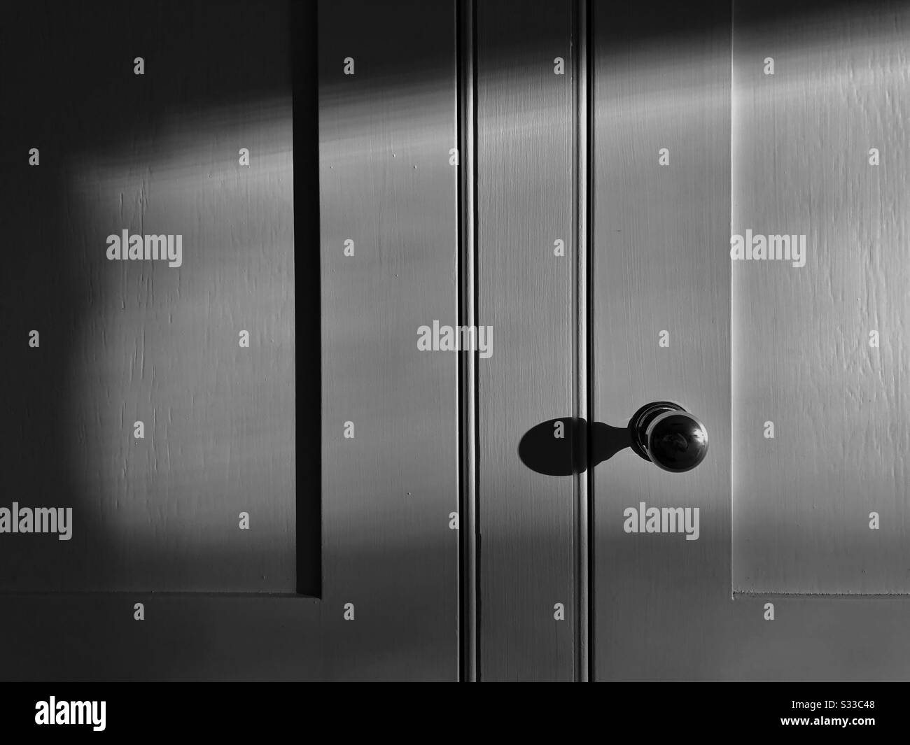 Low morning sunlight spilling into the kitchen creating dramatic sideways shadows on handmade kitchen cupboard. - Smartphone Captured Stock Image