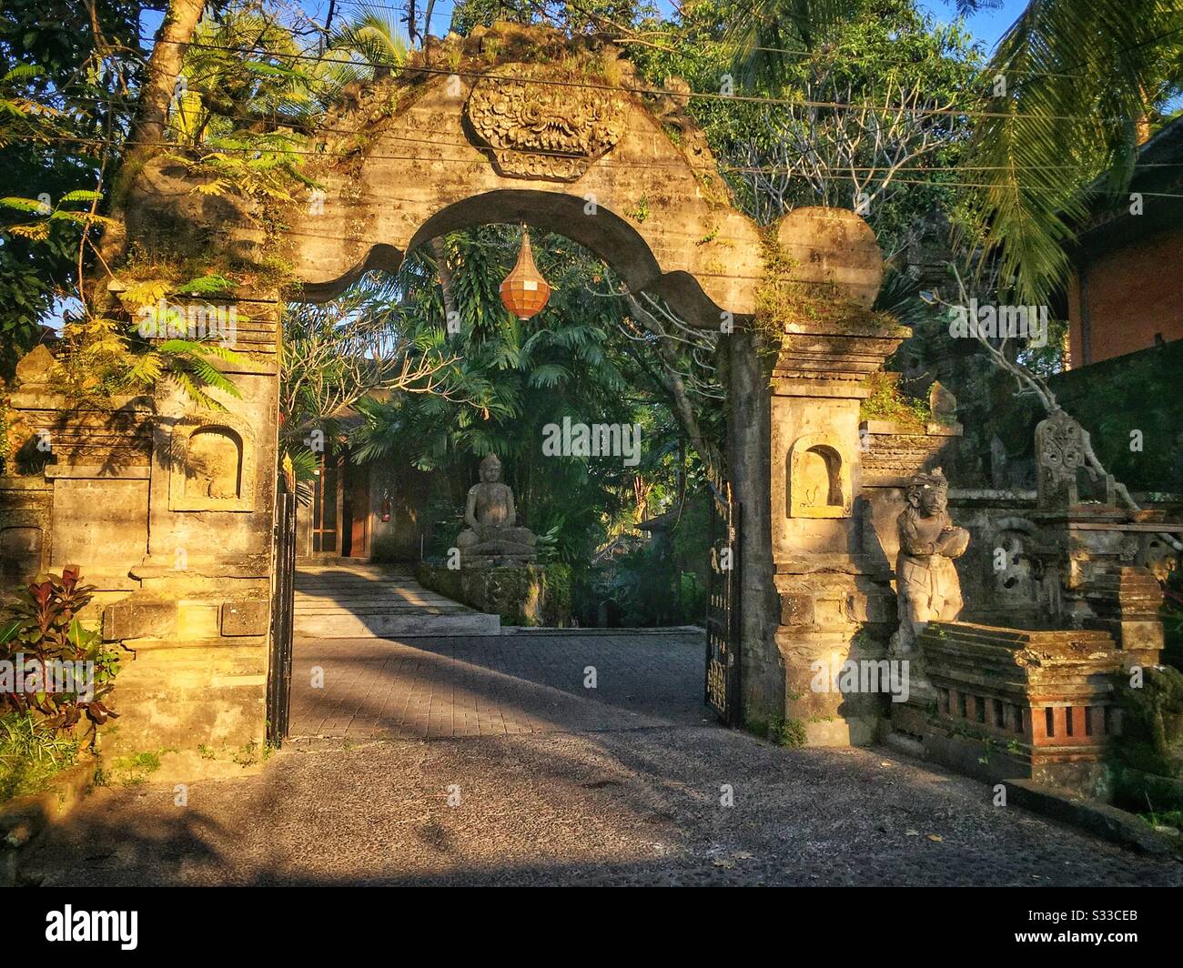 Decorative stone archway frames the entrance to a house, Ubud, Bali, Indonesia - Smartphone Captured Stock Image