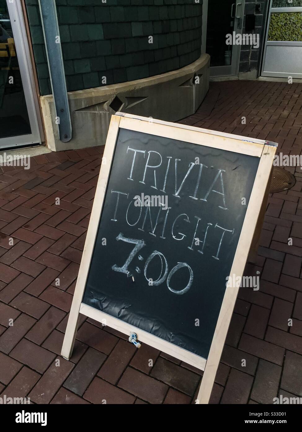 Trivia Night at a local pub, Halifax, Canada. Handwritten sign in chalk on the sidewalk. Come one come all. Not just a drink. Popular activity. - Smartphone Captured Stock Image