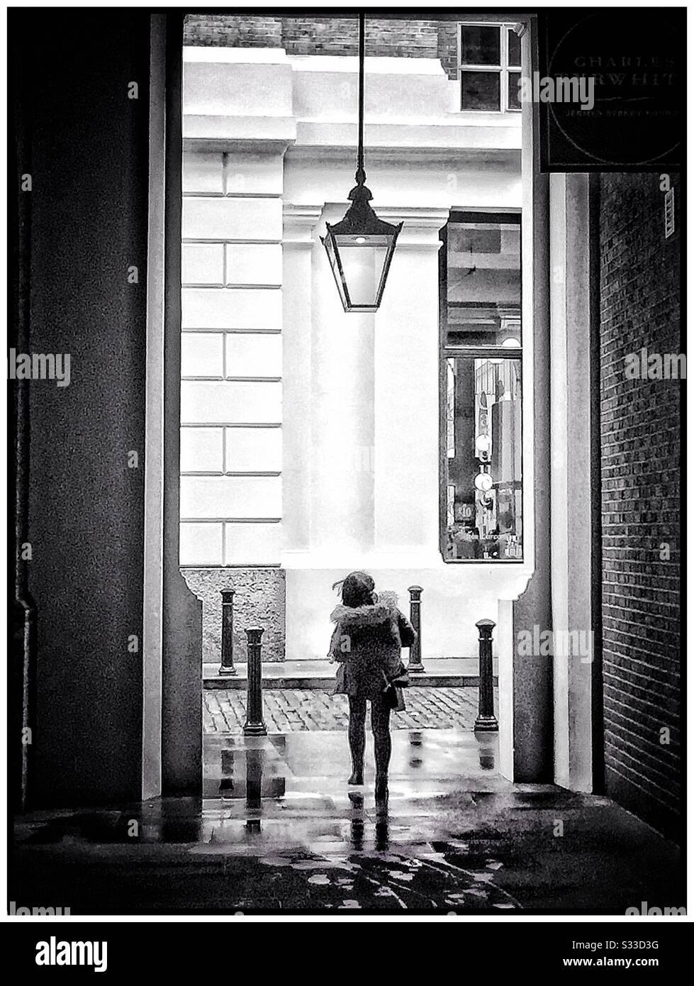A woman walking through an arch near London Bridge. - Smartphone Captured Stock Image