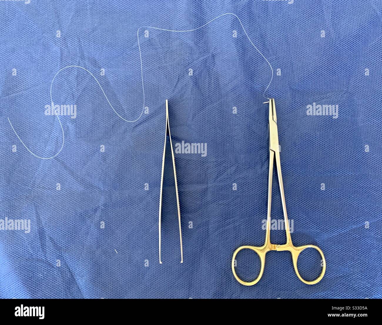 Surgical Instruments: Needle Holder, Adson Forceps  and Suture Needle. Stock Photo