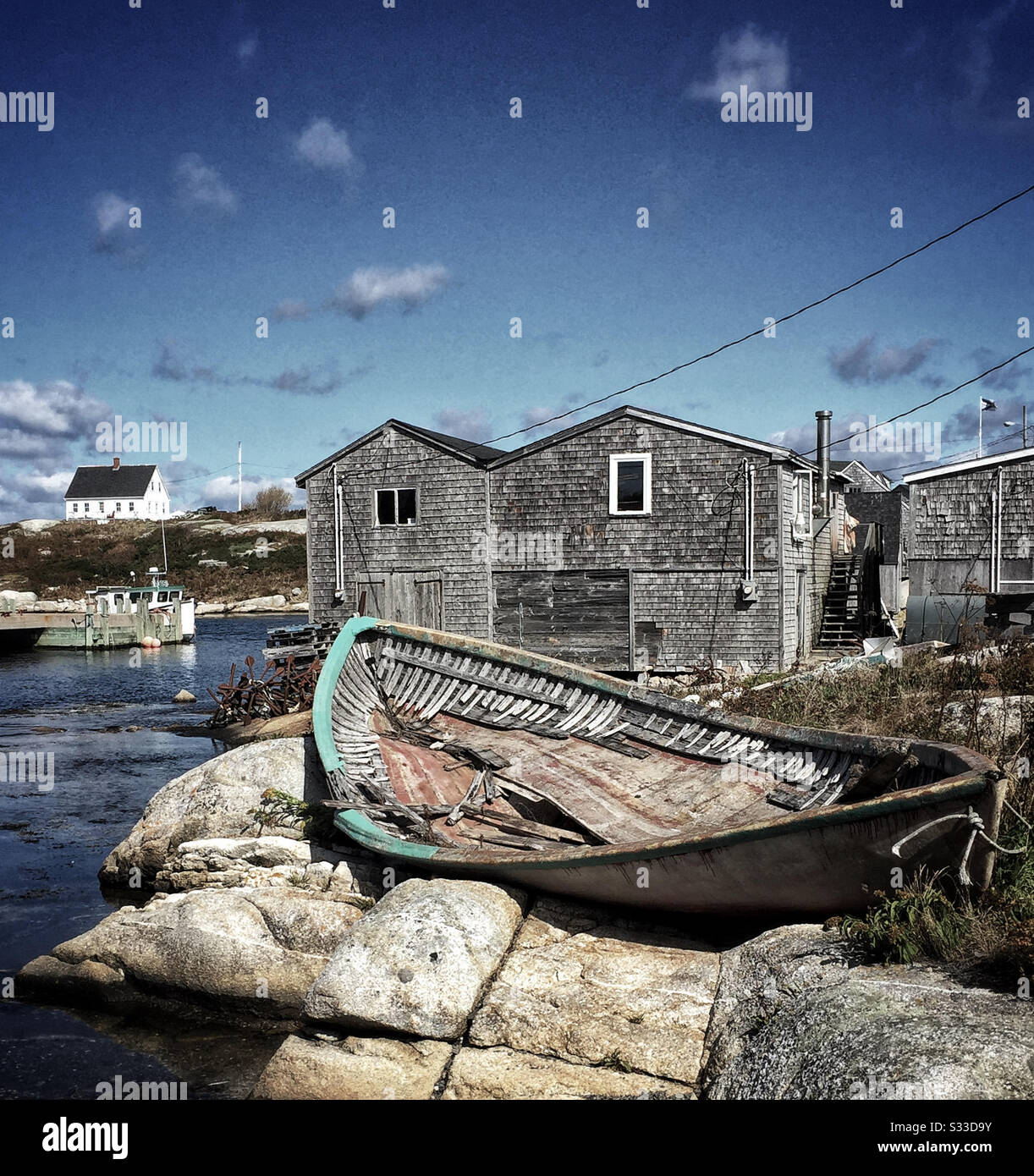 Broken shell of a wooden boat on rocks in a Nova Scotia fishing village Stock Photo