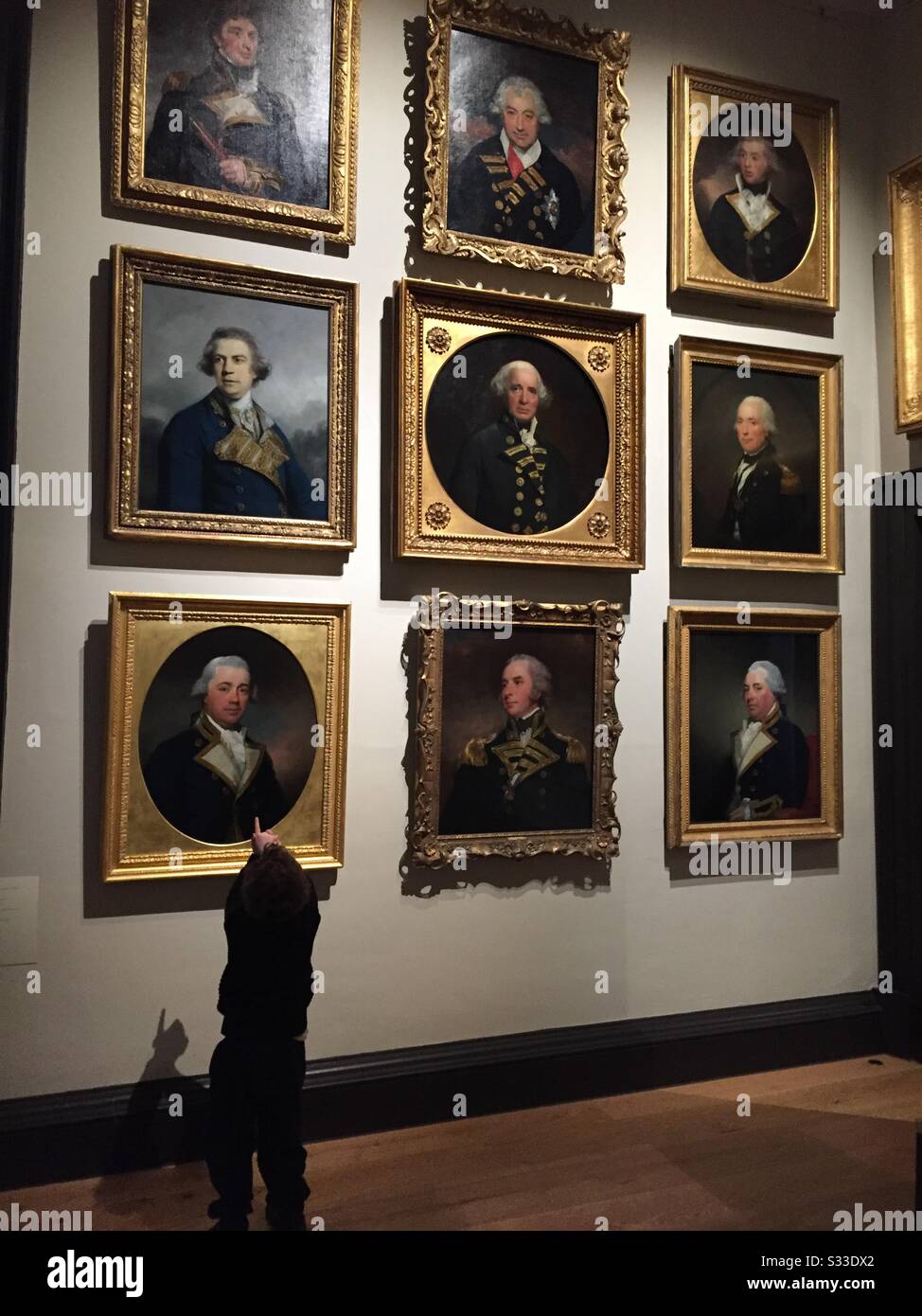 Toddler looking at art sea captains - Smartphone Captured Stock Image