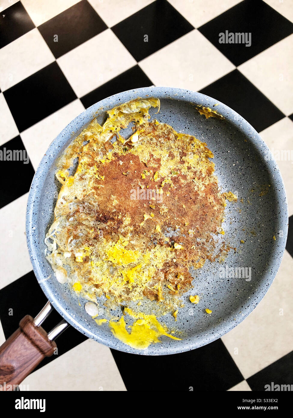 Eggs stuck to nonstick pan in kitchen Stock Photo