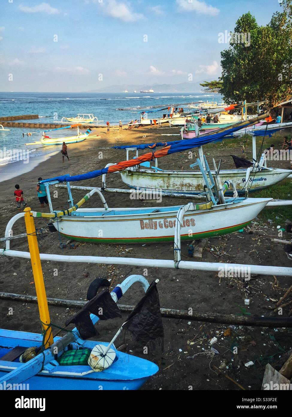 Traditional outrigger fishing boats on the beach at Candidasa, Bali, Indonesia - Smartphone Captured Stock Image