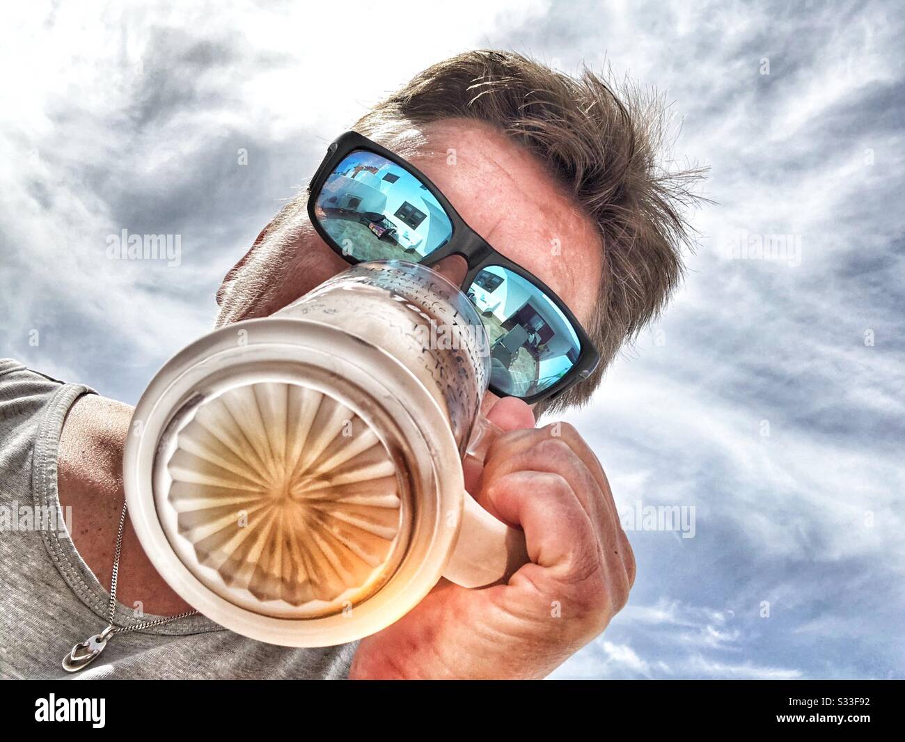Photo looking up of woman drinking a glass of lager - Smartphone Captured Stock Image