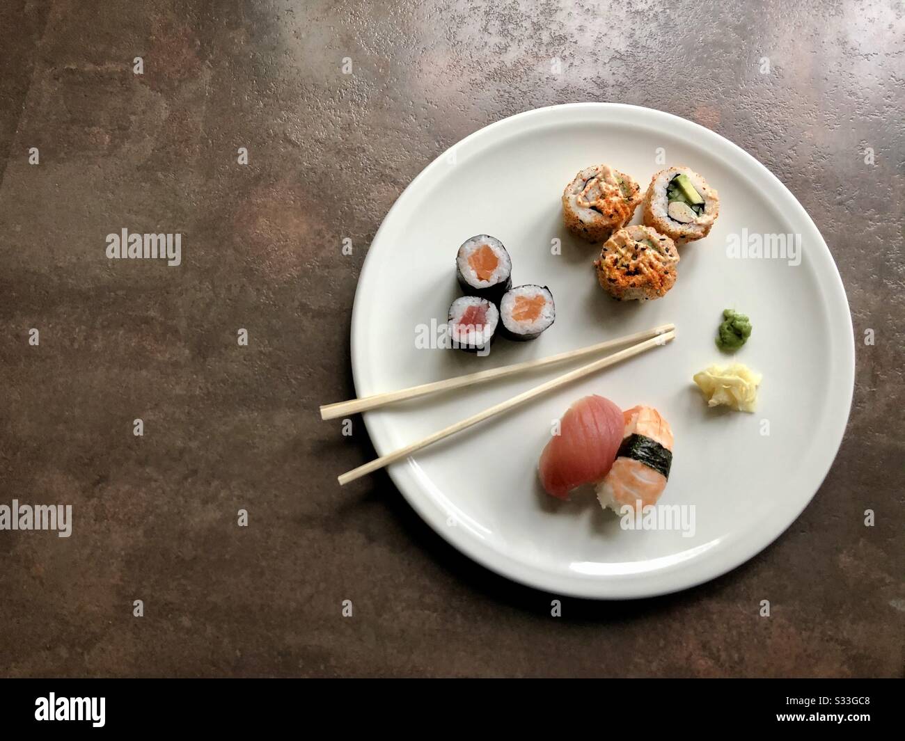 Top view of sushi, ginger and wasabi on a white plate with chopsticks - Smartphone Captured Stock Image