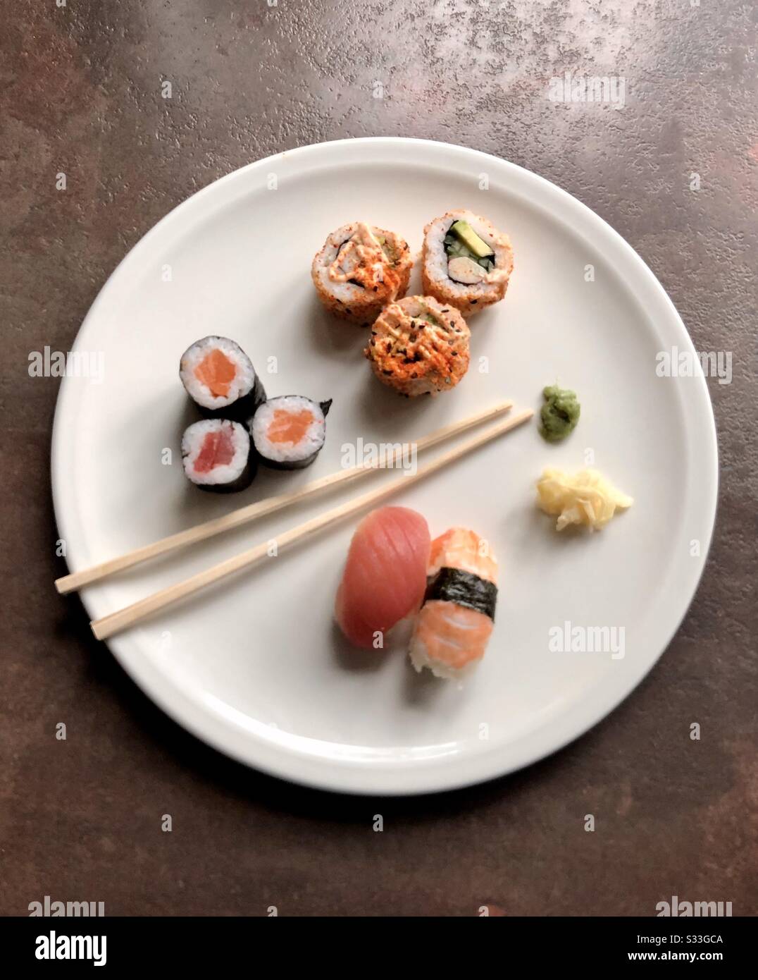 Top view of sushi, ginger and wasabi on a white plate with chopsticks - Smartphone Captured Stock Image