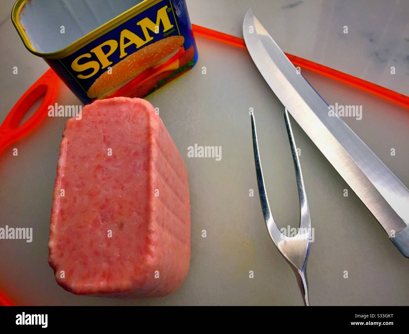 Freshly opened can of Spam and carving set on a cutting board - Smartphone Captured Stock Image