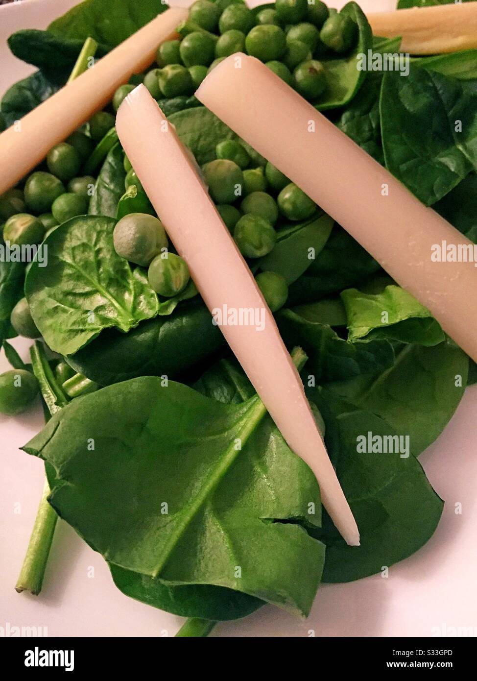 Flat lay close up of a spinach salad with fresh peas and hearts of palm - Smartphone Captured Stock Image