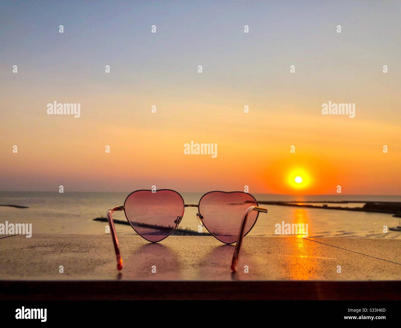 Heart shaped sunglasses at sunset in summer - Smartphone Captured Stock Image