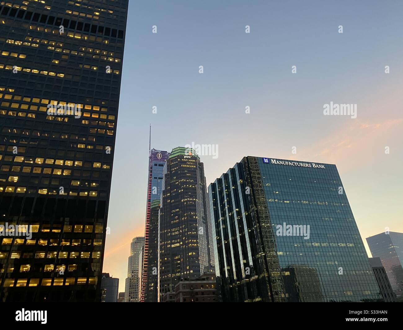 LOS ANGELES, CA, JAN 2020: dark skyscraper in foreground with other tall buildings behind against sunset sky, Financial District, Downtown. Copy space provided. - Smartphone Captured Stock Image