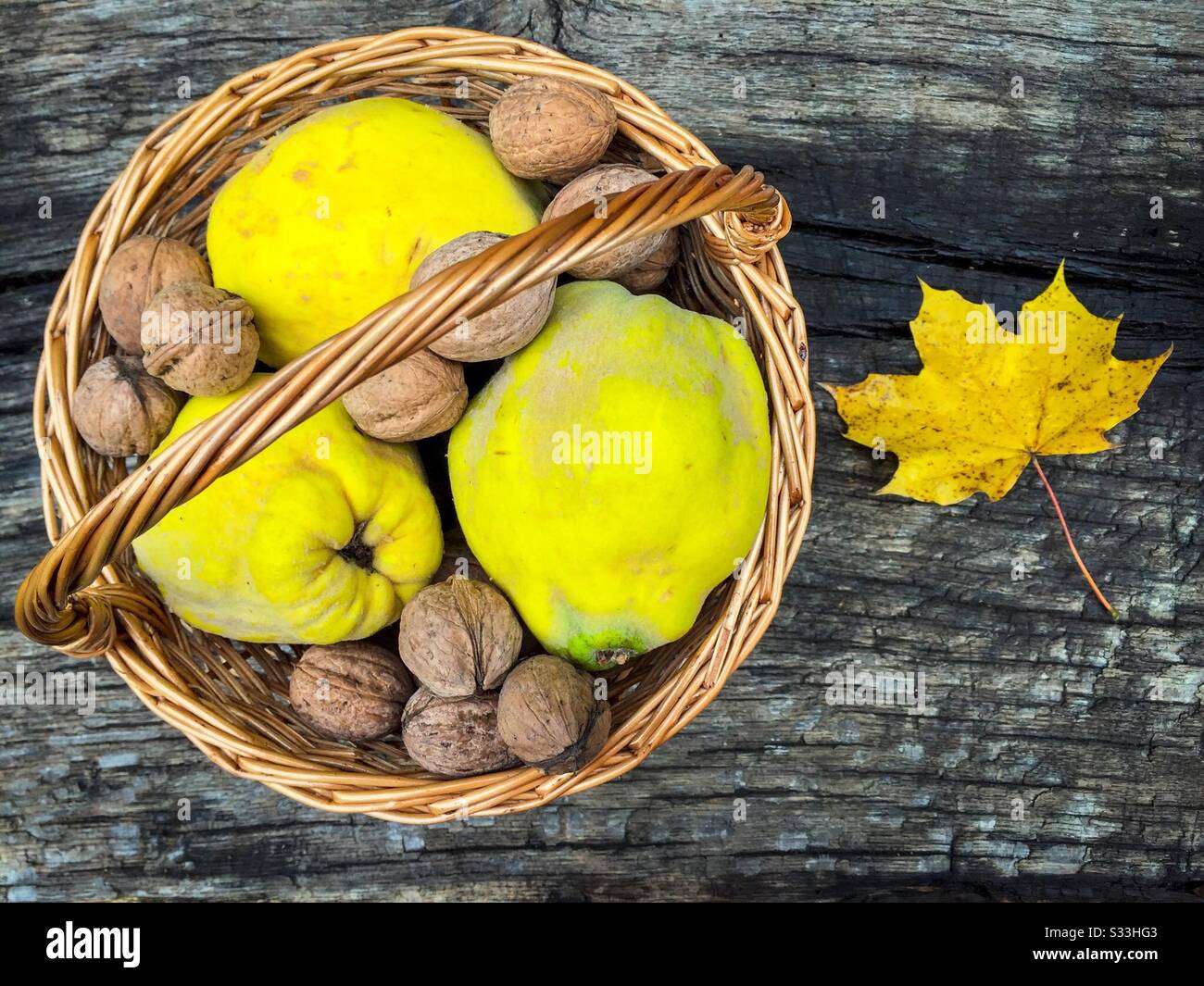Basket with nuts and quinces on rustic wooden table - Smartphone Captured Stock Image