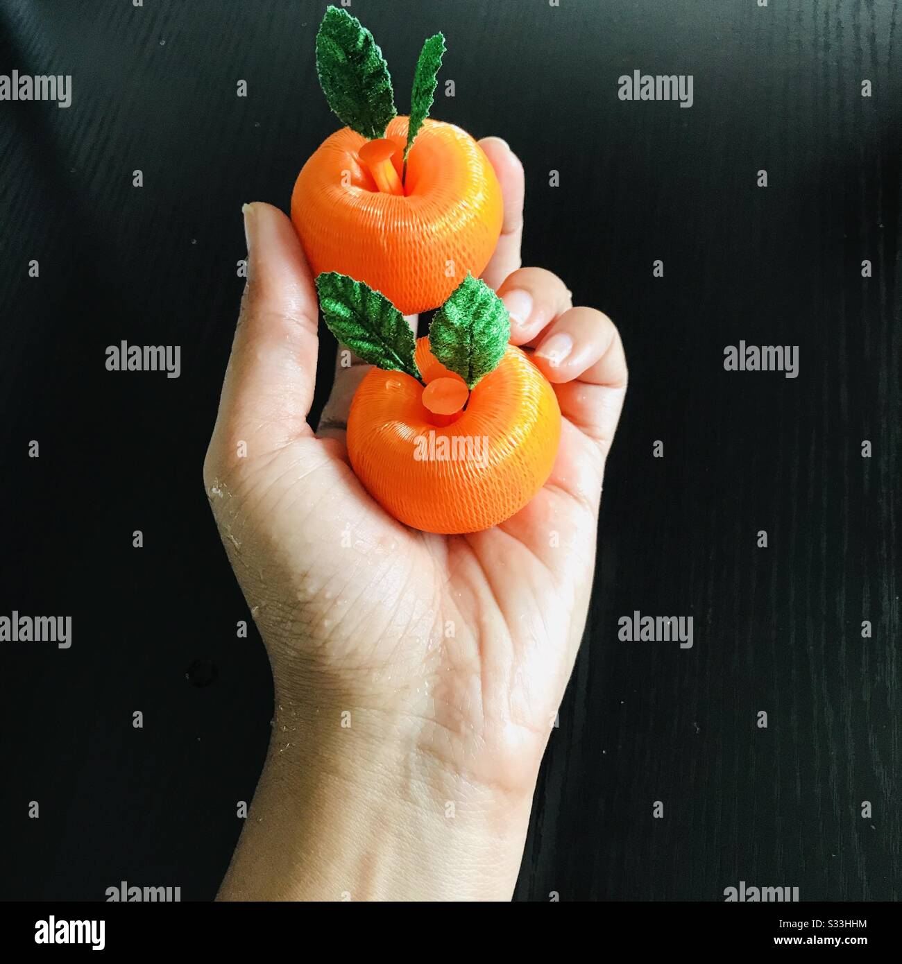 Handmade two mandarin oranges holding in a palm, Symbol of Chinese New Year  ,Lunar New Year- wishes , close up pic - colour change mode-hand holding  oranges Stock Photo - Alamy