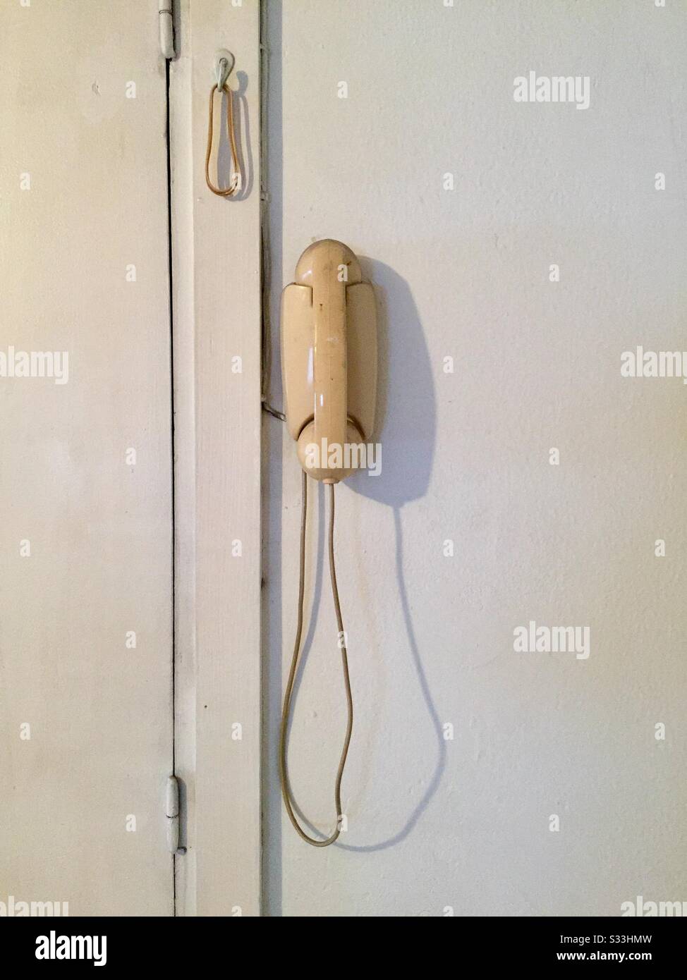old white telephone on the white wall Stock Photo