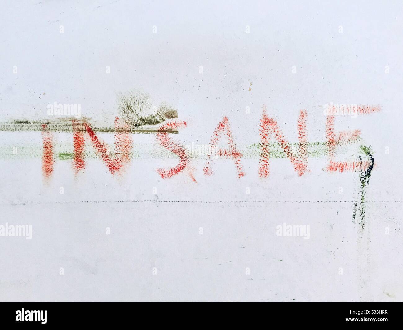 insane letters painted on the white wall Stock Photo