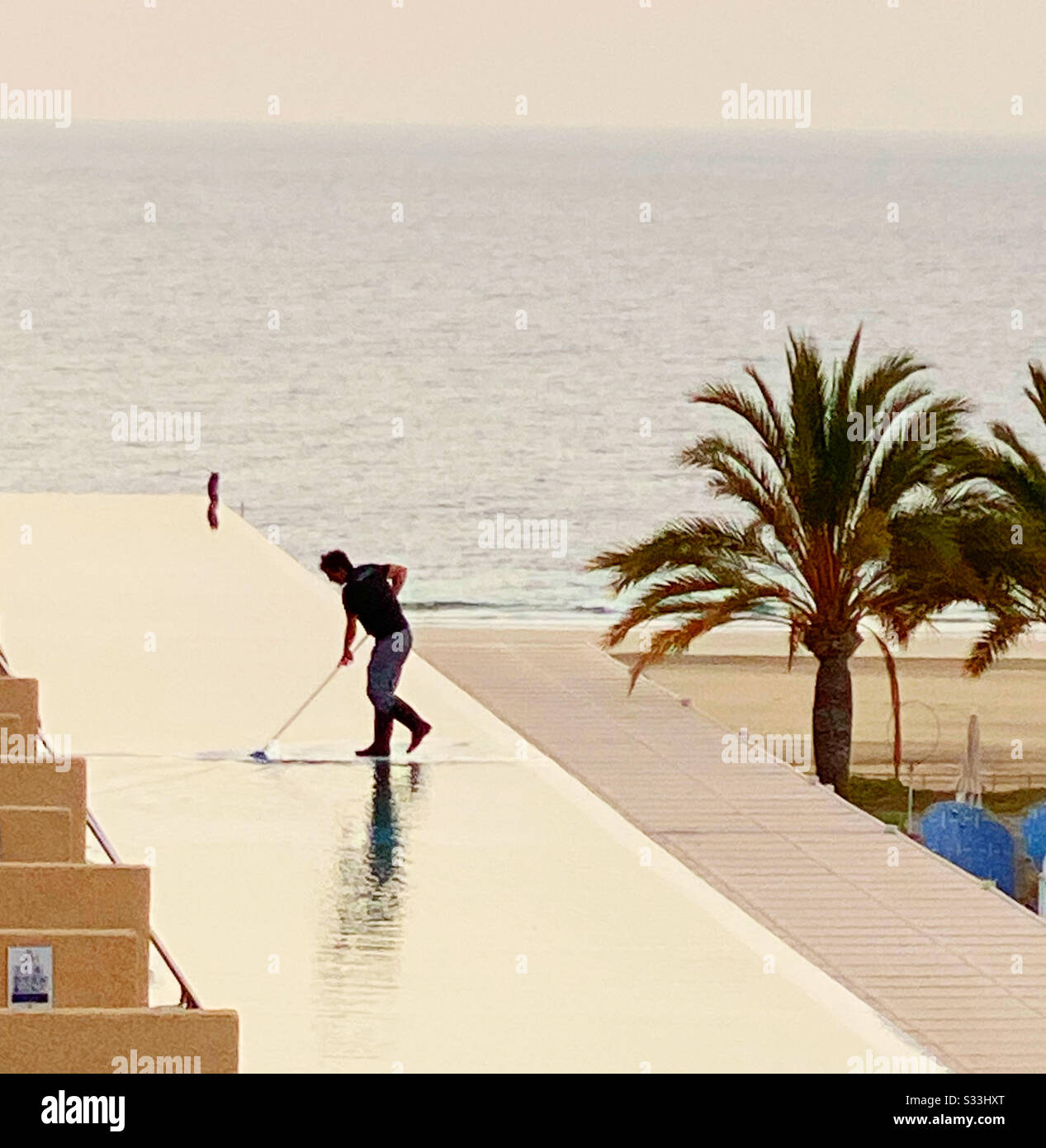 Someone goes over the water. Hard working. Pool- Cleaner. - Smartphone Captured Stock Image