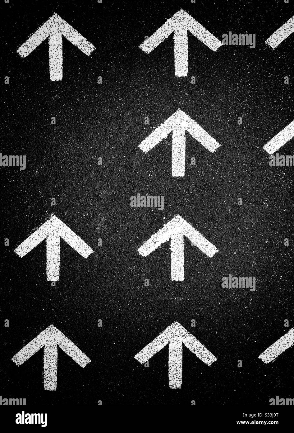 White arrows pointing up. Arrows pointing North. This way. The only way is up! Photo Credit - © COLIN HOSKINS. - Smartphone Captured Stock Image