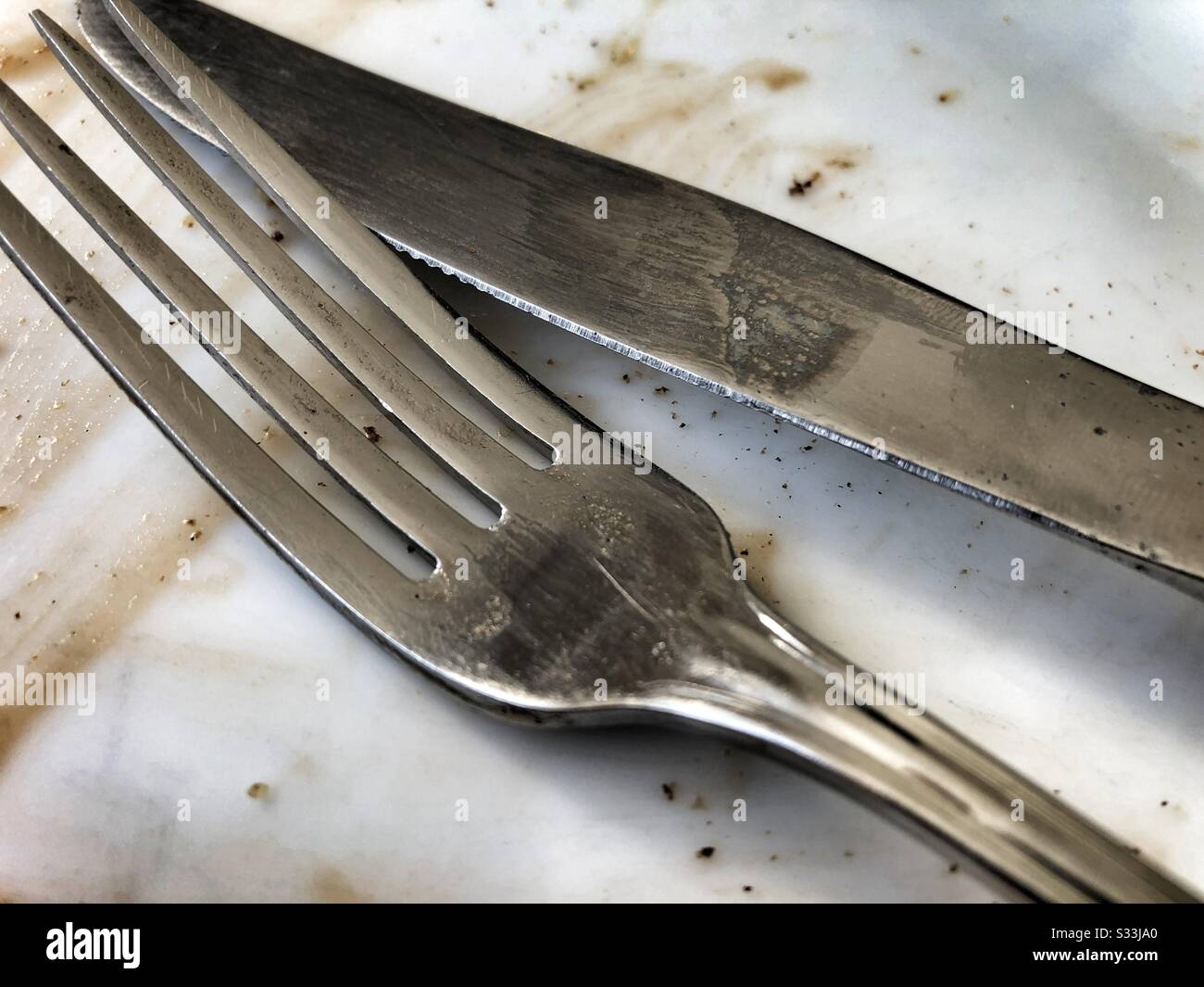 Knife and fork on an empty dinner plate - Smartphone Captured Stock Image