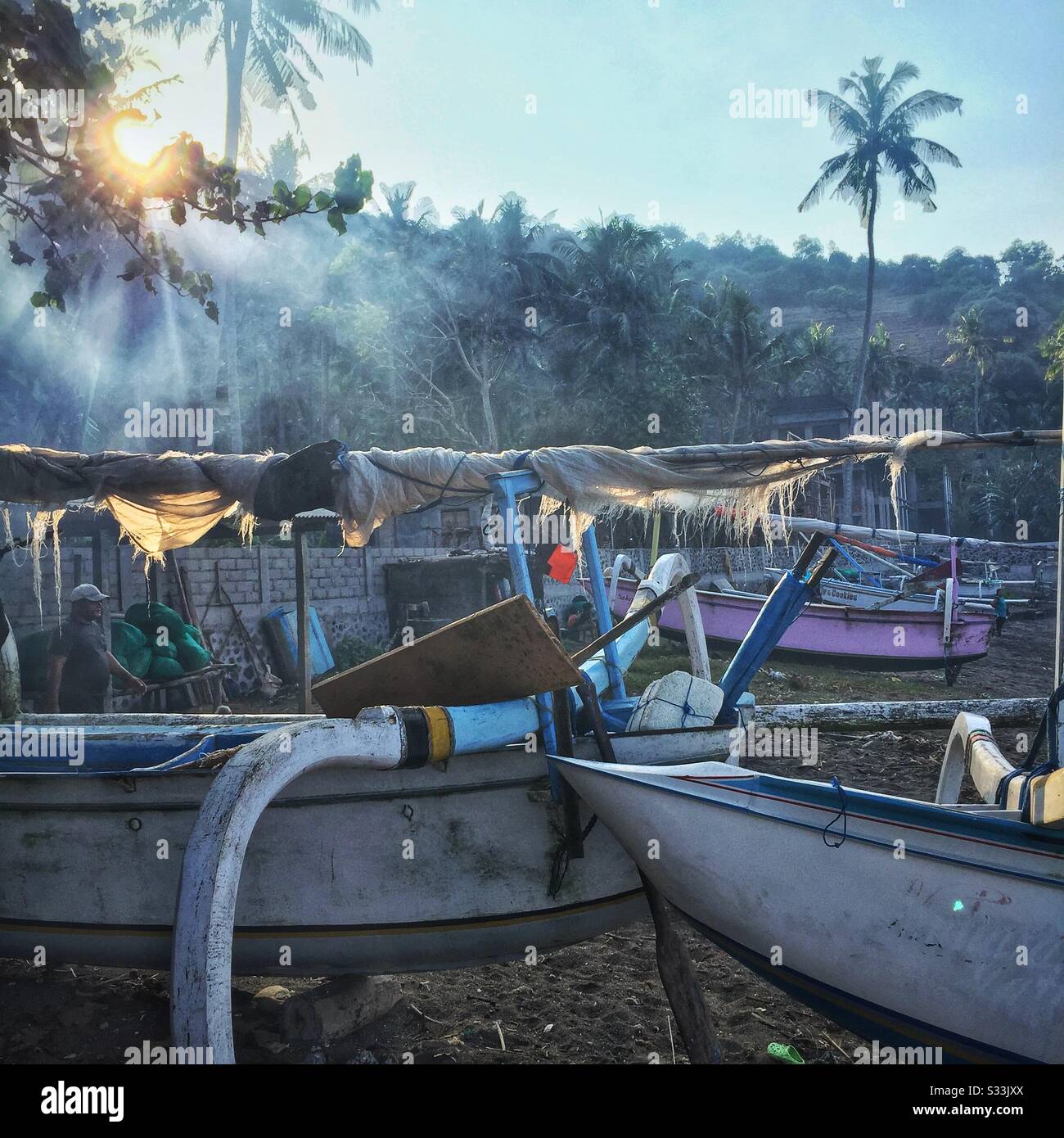 Traditional outrigger fishing boats on the beach at Candidasa, Bali, Indonesia - Smartphone Captured Stock Image
