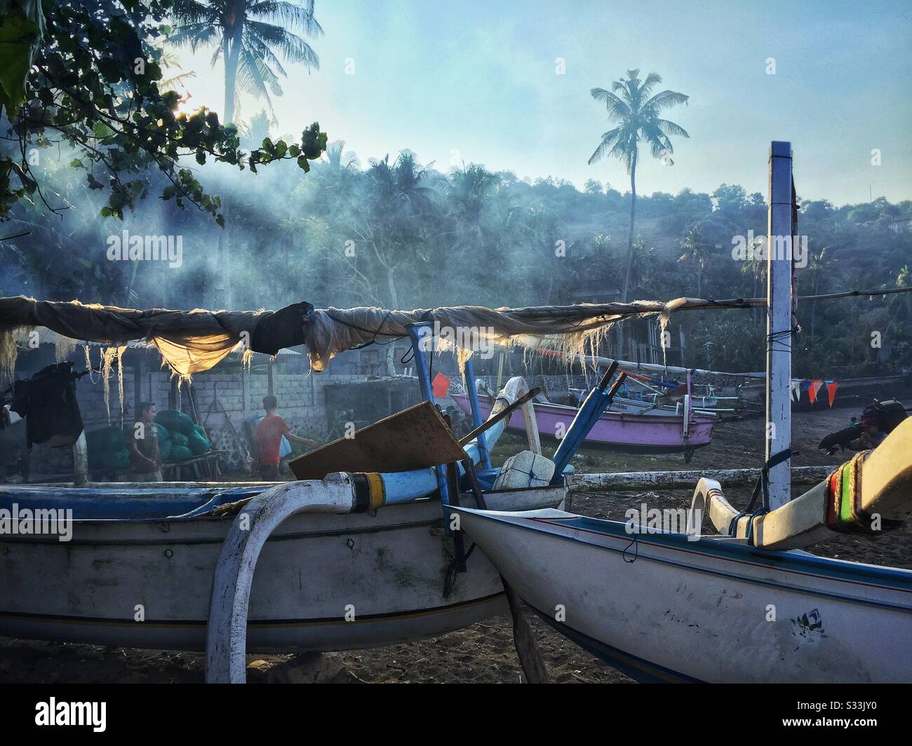Traditional outrigger fishing boats on the beach at Candidasa, Bali, Indonesia - Smartphone Captured Stock Image