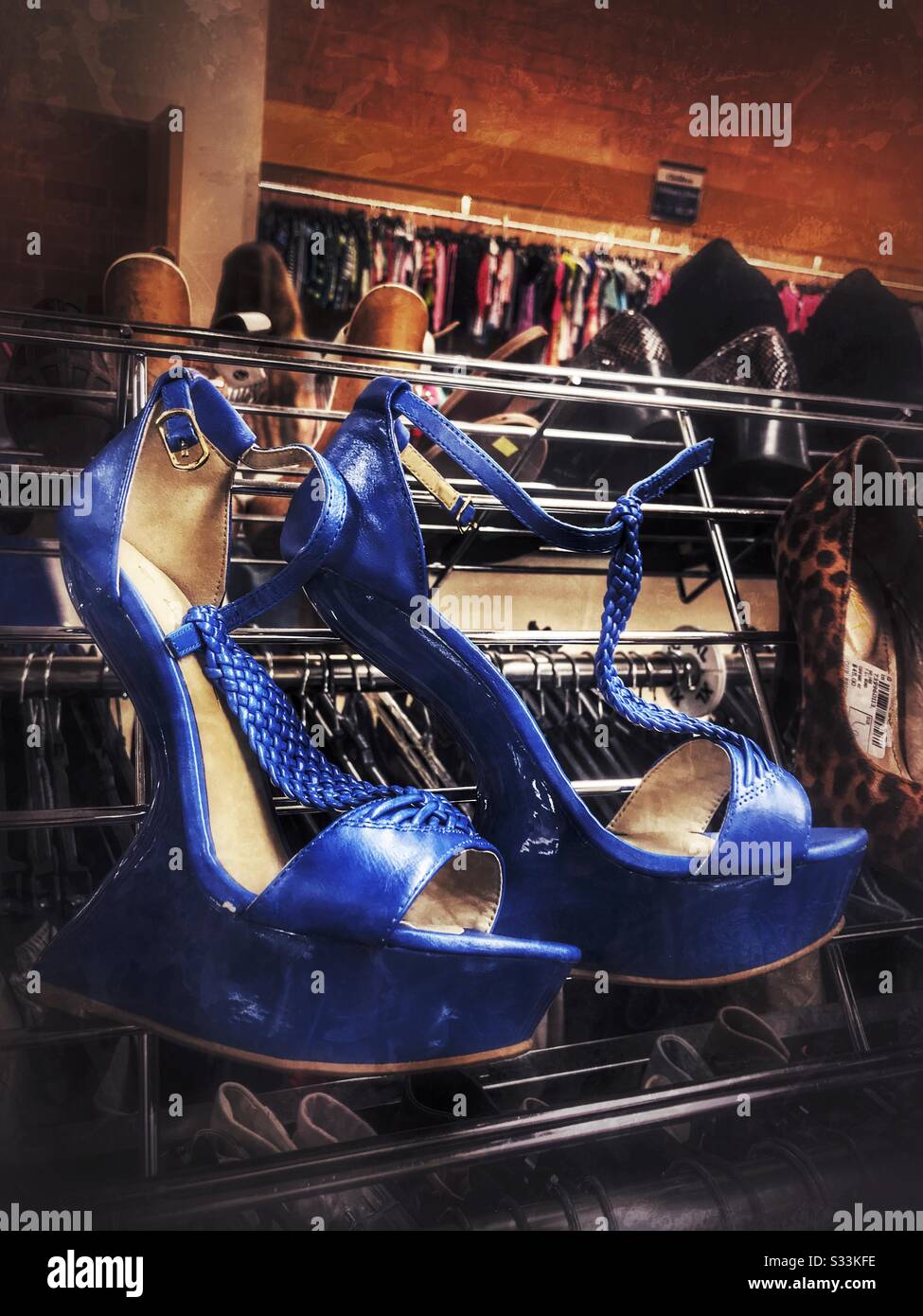 Grunge photo of women’s odd blue platform sandals on display in thrift shop Stock Photo