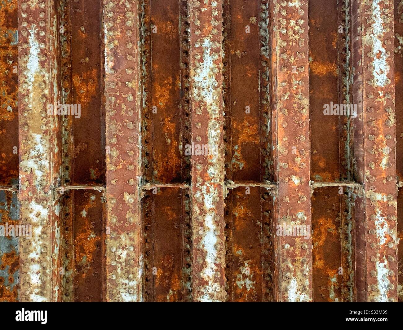 Rusty steel I beams laid out under the El train in Chicago Stock Photo