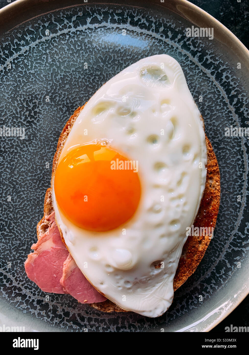 Fried egg and beef toasted wholemeal bagel Stock Photo