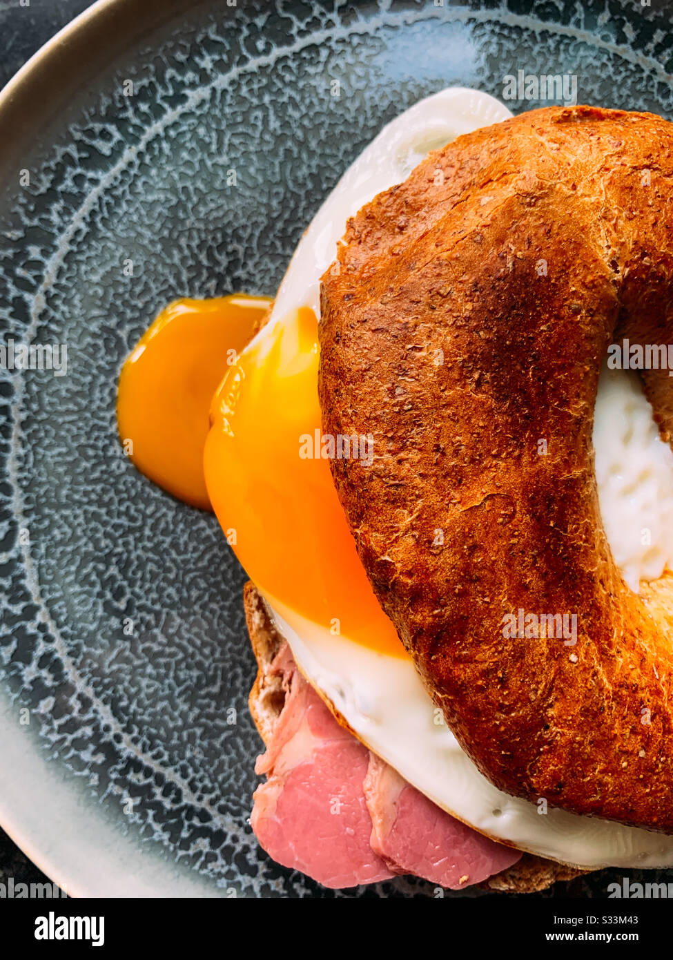 Toasted egg and beef wholemeal bagel with a runny yolk - Smartphone Captured Stock Image