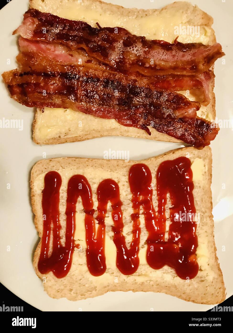 Bacon on brown buttered bread with tomato ketchup, open breakfast