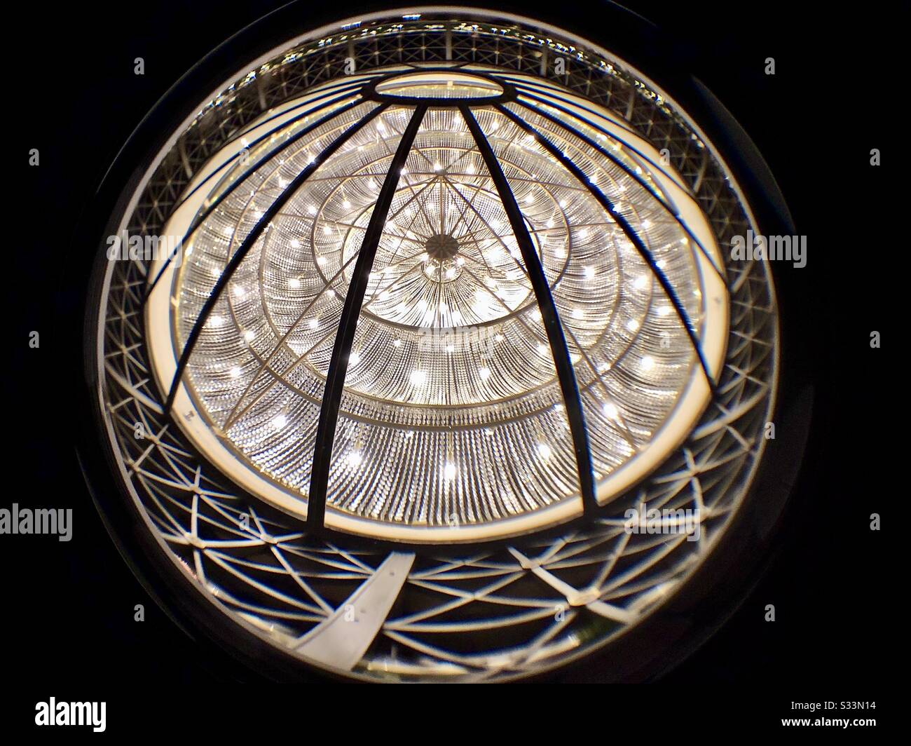 Unique perspective of an interior dome in the floor below.  Surrounded by a railing, and lit from below. Stock Photo