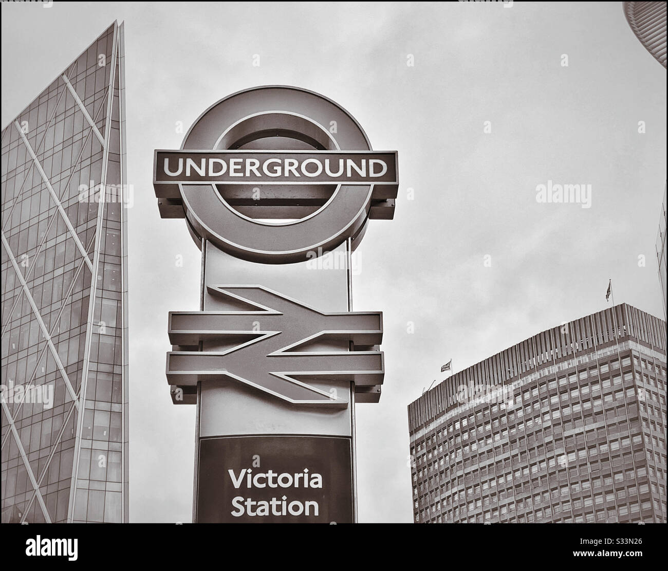 A monochrome picture of the famous London Underground and British Rail signs at Victoria Station. Photo Credit - © COLIN HOSKINS. Stock Photo