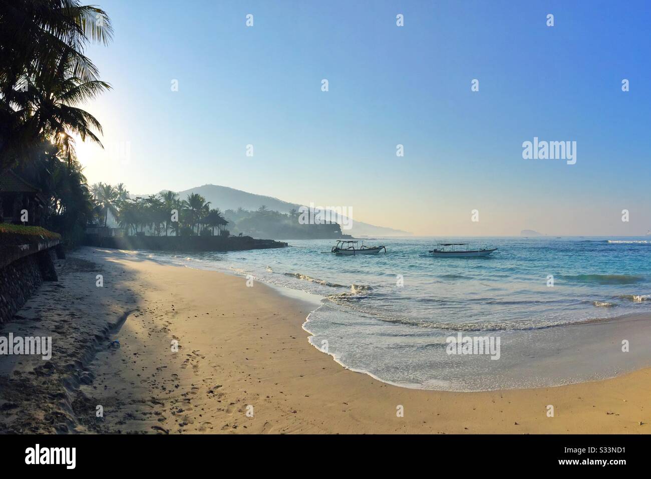 Traditional outrigger fishing boats moored at Pantai Anom (Anom Beach), Candidasa, Bali, Indonesia - Smartphone Captured Stock Image