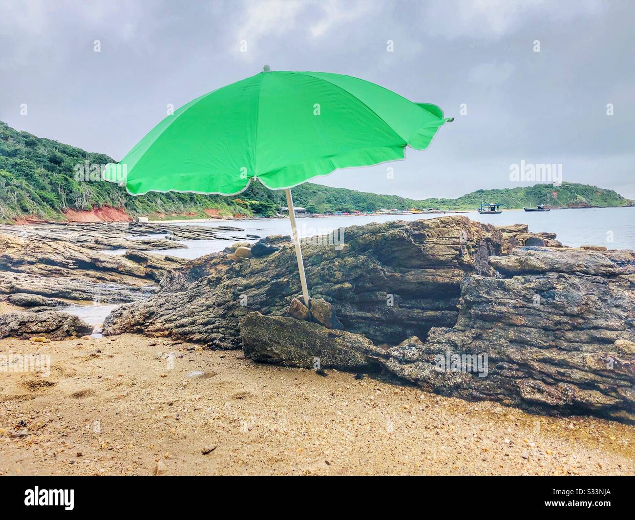 A green sun umbrella on the beach. Stock Photo