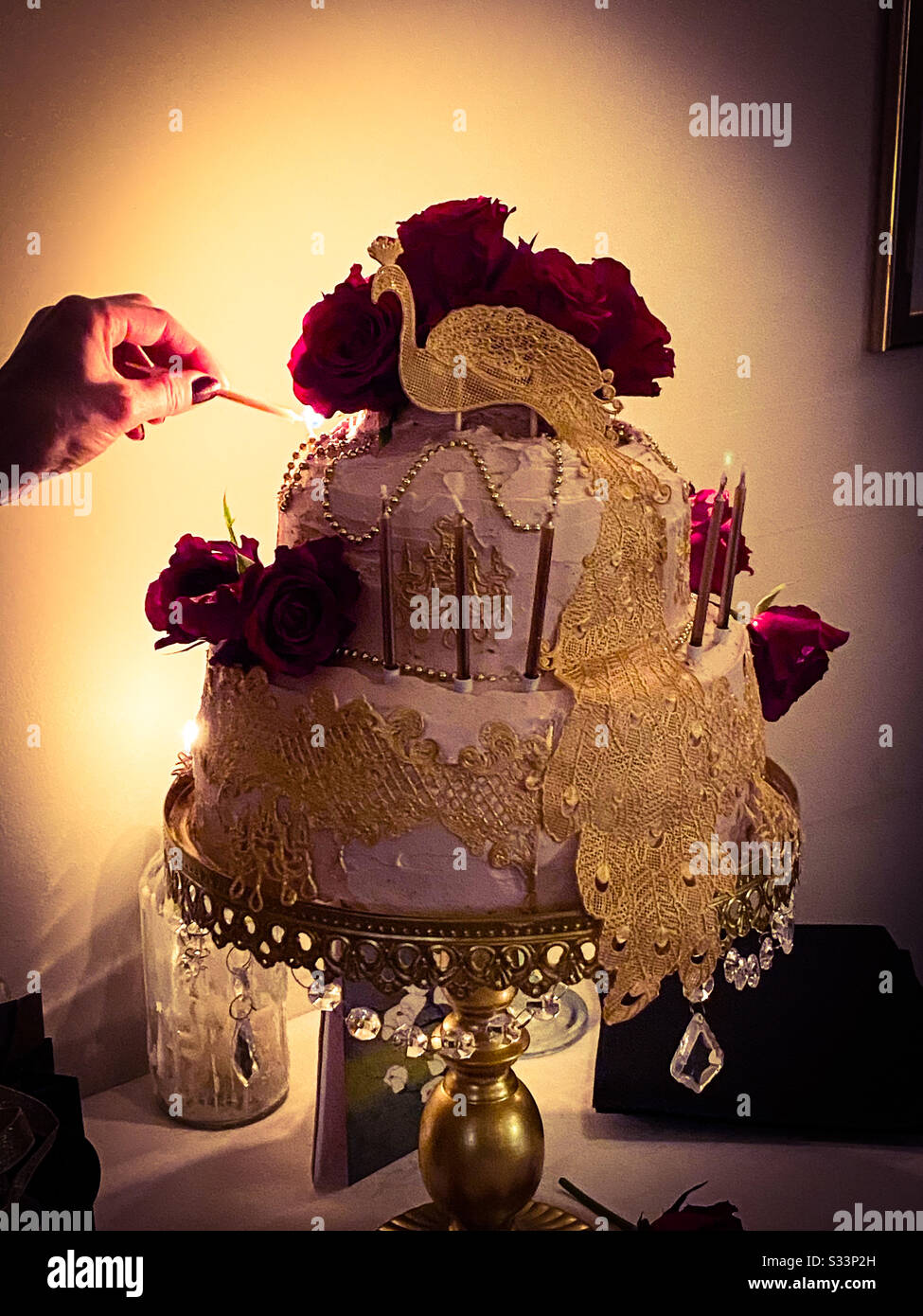 A photograph of an elaborate birthday cake taken in candle light. - Smartphone Captured Stock Image