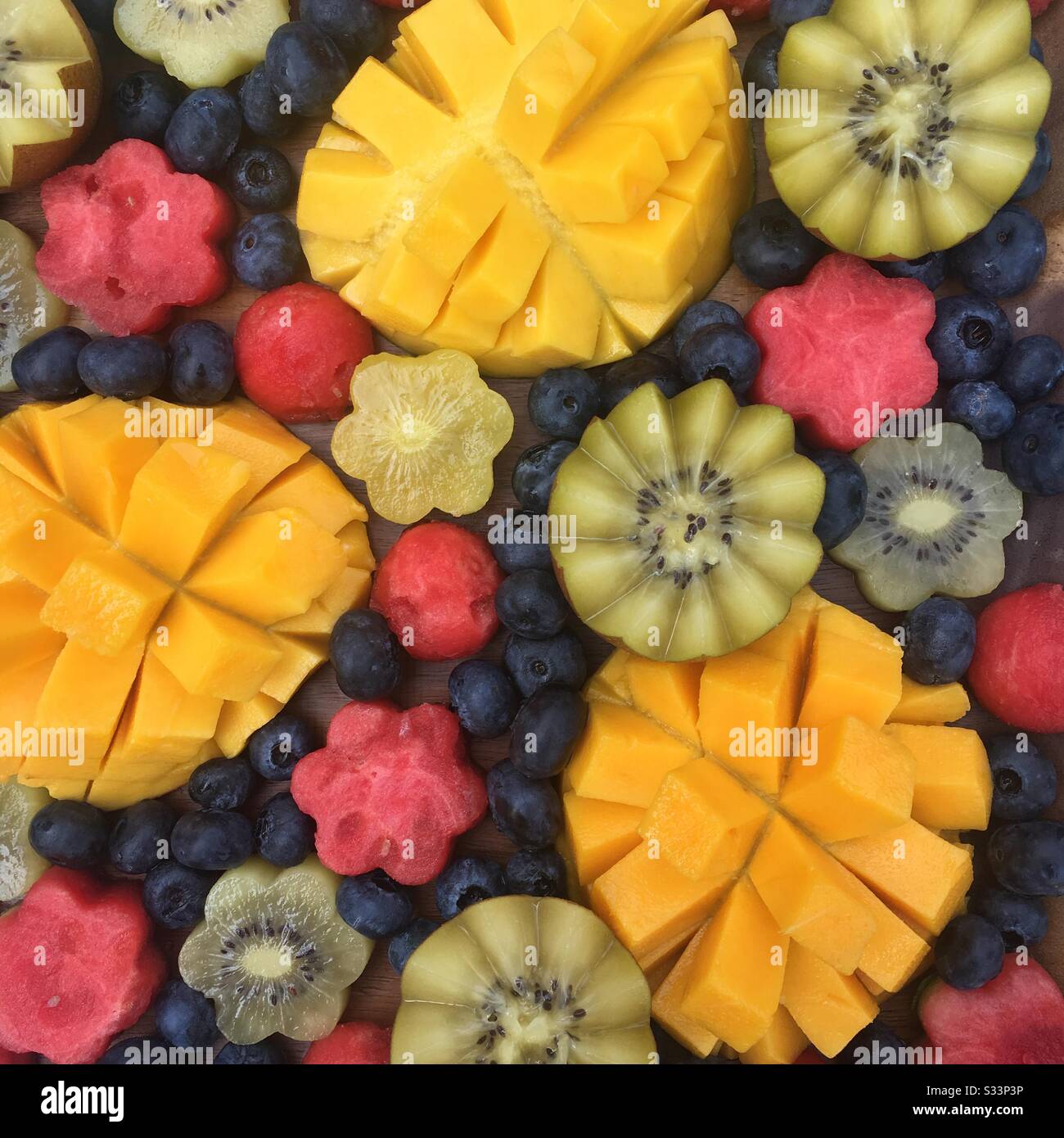 Beautiful fruit platter with mangoes, watermelon, kiwi, and blueberries