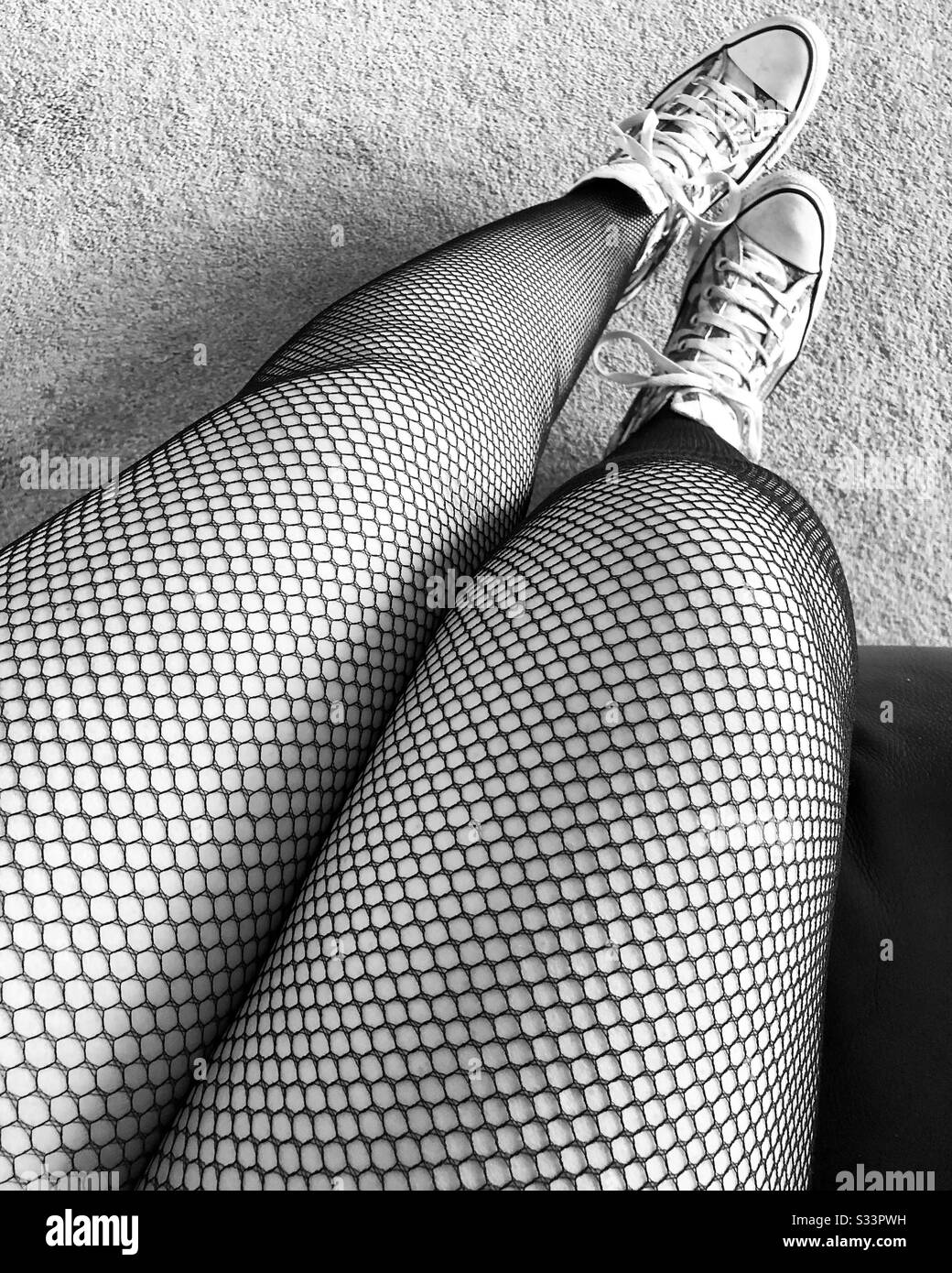 Touching her legs in a seamed fishnet stockings in market