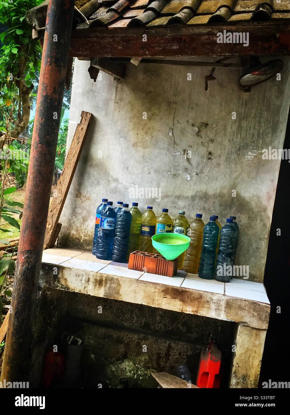 Petrol for sale in reused plastic water bottles, Candidasa, Bali, Indonesia - Smartphone Captured Stock Image