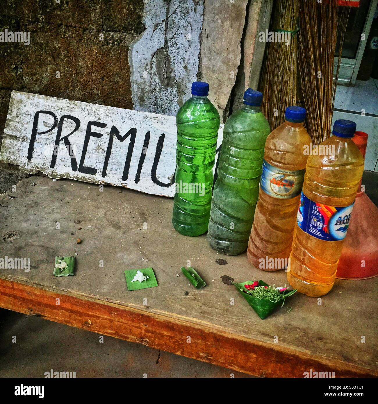 Petrol for sale in reused plastic water bottles, Candidasa, Bali, Indonesia - Smartphone Captured Stock Image