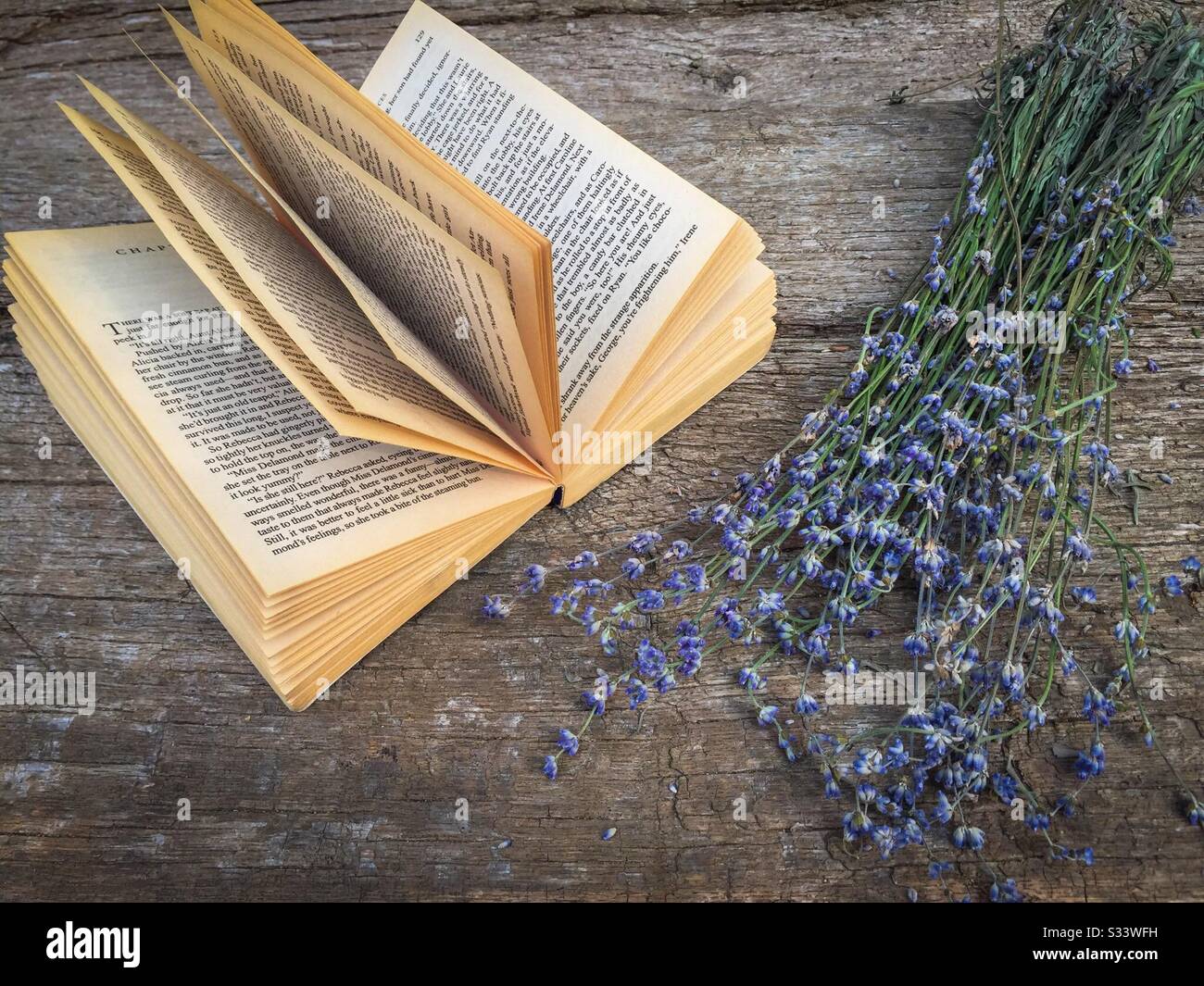 Book and lavender flowers on rustic wooden table - Smartphone Captured Stock Image