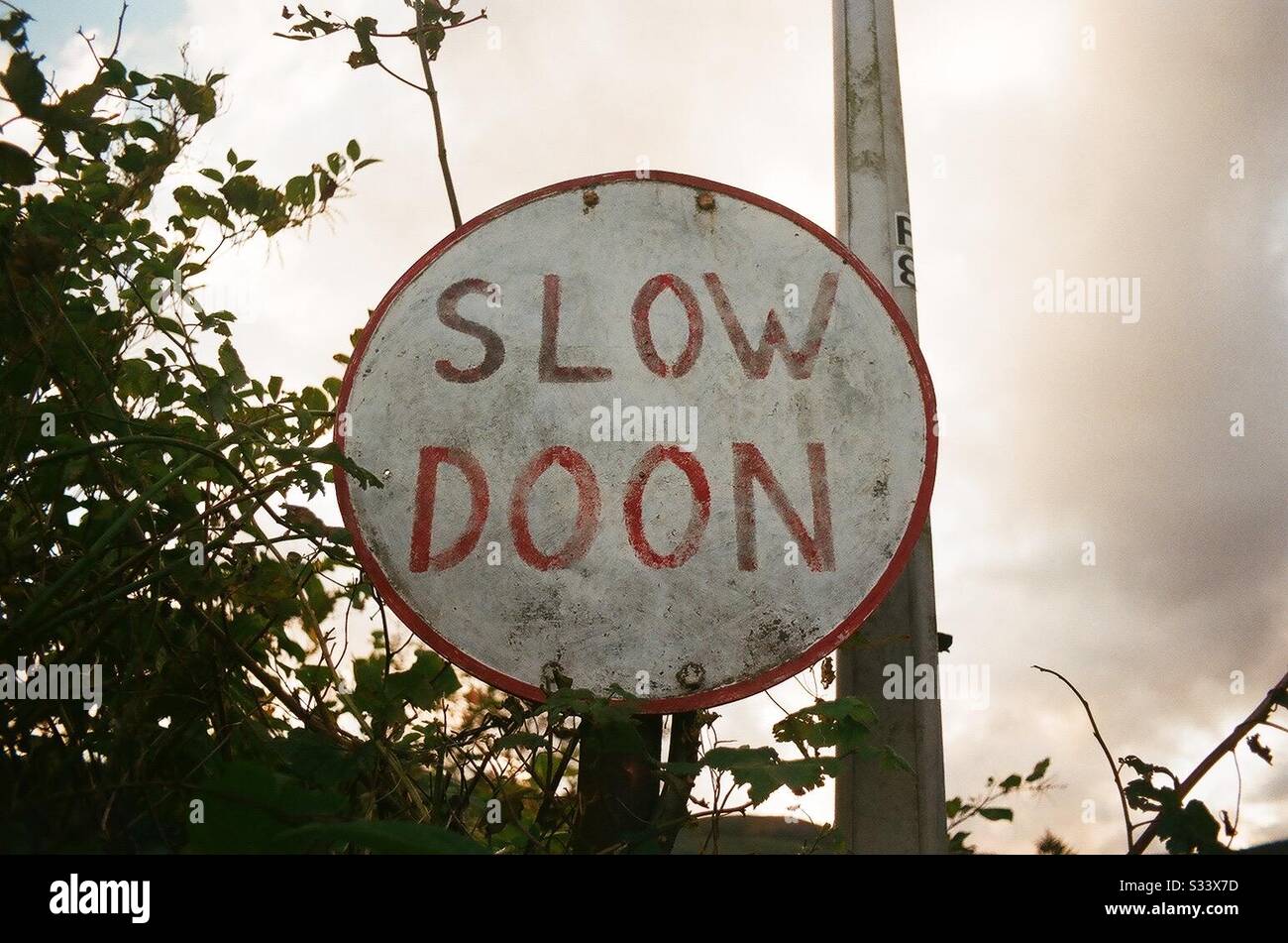 “Slow doon” advises a sign on a single track road in Scotland - Smartphone Captured Stock Image