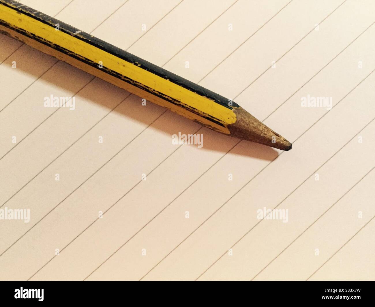 Worn pencil resting on lined notepaper - Smartphone Captured Stock Image
