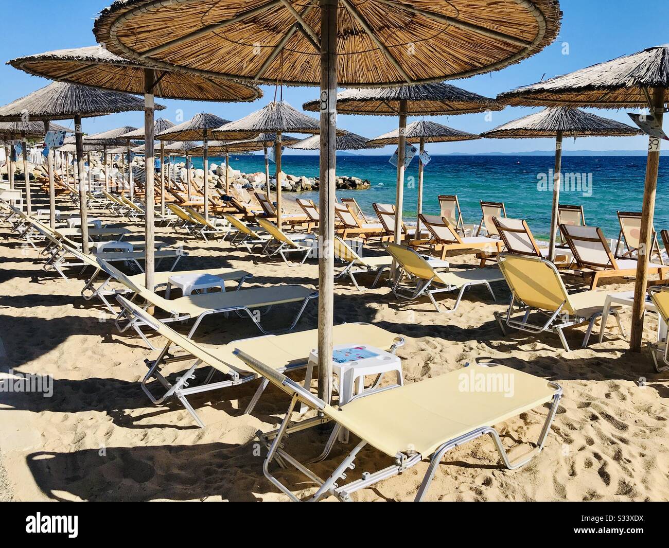 Nikiti beach in the village of Nikiti, Sithonia peninsula, Chalkidiki,  Central Macedonia, Greece. Sun beds and umbrellas Stock Photo - Alamy