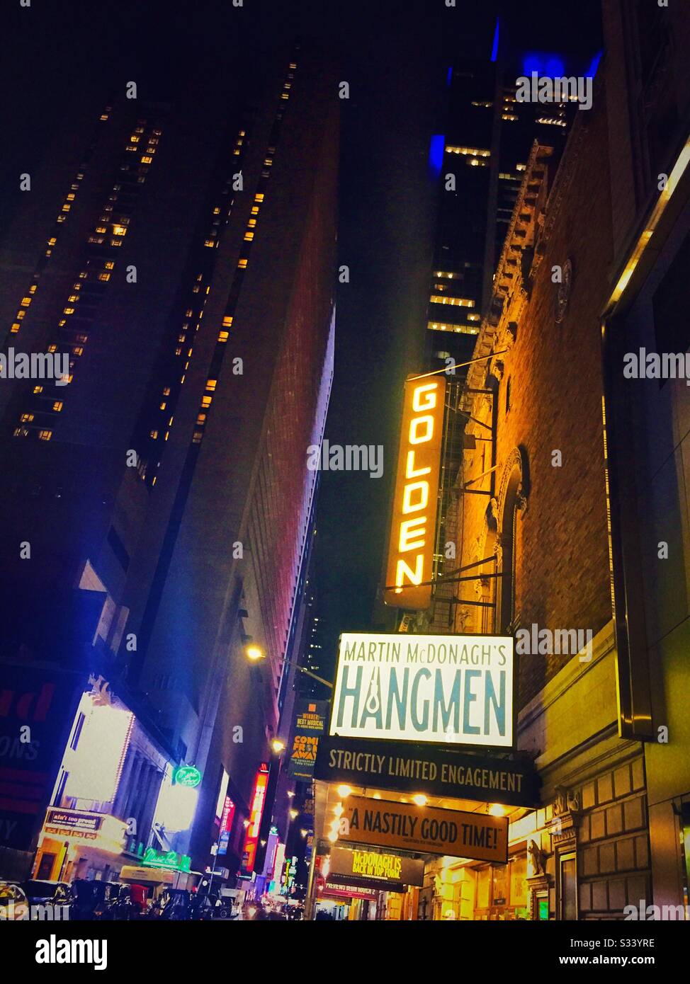 The golden theater on W. 45th St. in Times Square is awash in lights and features the drama hangmen, NYC, USA - Smartphone Captured Stock Image
