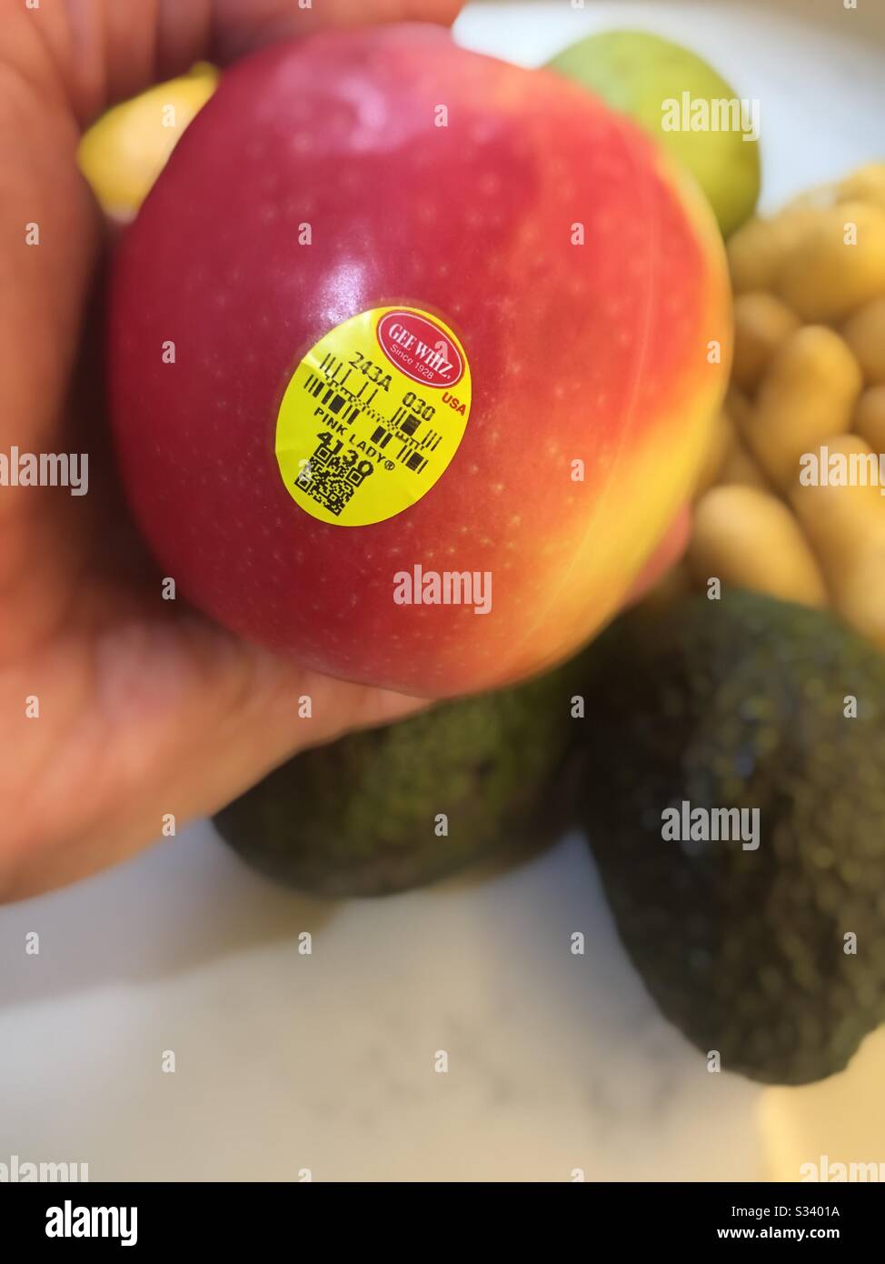 Man holding a pink lady apple in his hand, USA - Smartphone Captured Stock Image